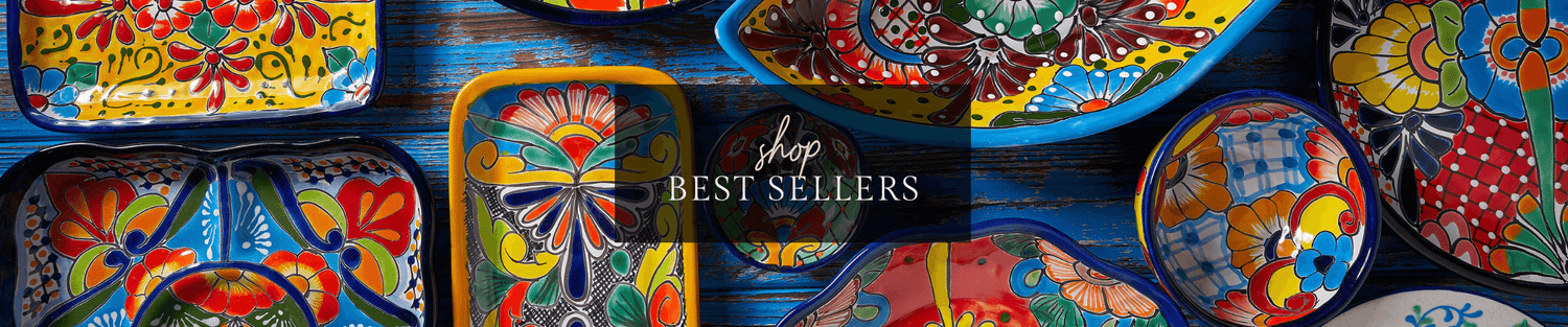 Colorful hand-painted Mexican Talavera ceramic bowls and dishes arranged on a blue wooden surface