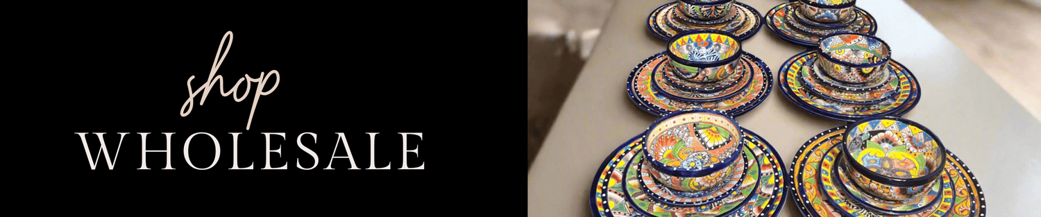 Hand-painted colorful mosaic ceramic bowls stacked in sizes beside a 'shop wholesale' sign