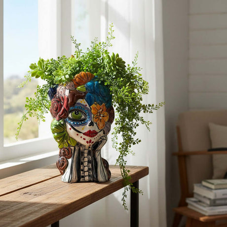 The Talavera Hub hand-painted ceramic Day of the Dead skull planter with floral motifs in red, green, blue, and yellow.