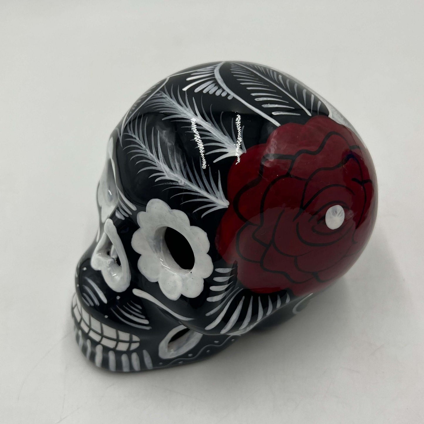 Guerrero Calavera Skull | Large Hand-Painted Day of the Dead Art - black hand-painted skull with white floral designs and red rose accent