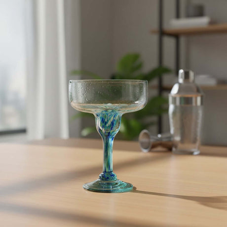 The Talavera Hub hand-blown margarita glass with blue green confetti accents on stem and base. Clear glass, 16 oz.