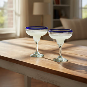 The Talavera Hub Hand-Blown Mexican Margarita Glass with cobalt blue rim and clear recycled glass body. Holds 16 oz.