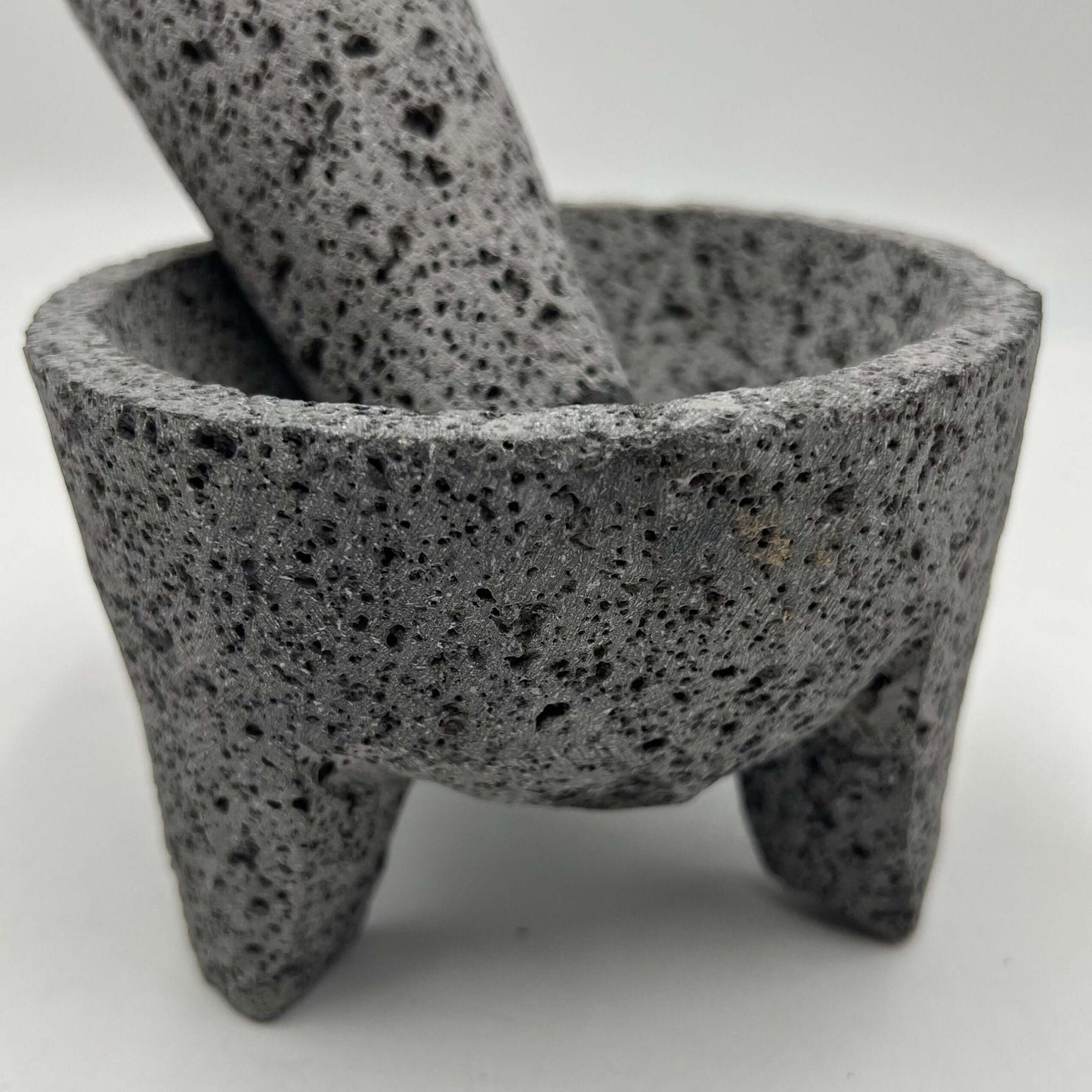 Mexican Volcanic Stone Molcajete | Handmade Mortar and Pestle close-up of textured volcanic stone molcajete with pestle, three-legged traditional design