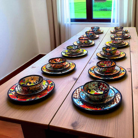 36-Piece Talavera Dinnerware Set | Handmade Mexican Plates & Bowls displayed in a row on a wooden table, hand-painted vibrant Talavera patterns