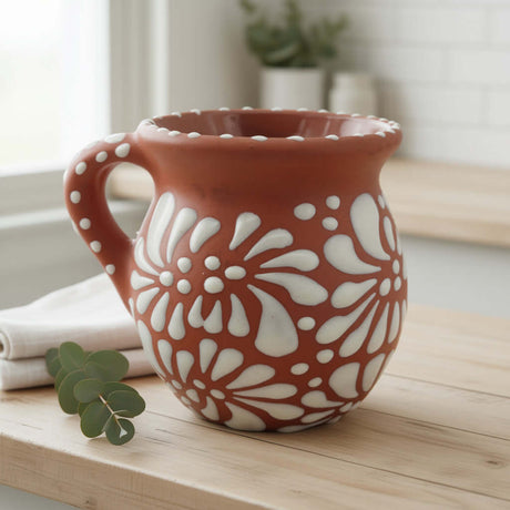 Ceramic mug with white floral patterns on a wooden surface