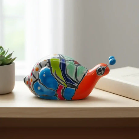 Mini Talavera Snail Figurine | Hand-Painted Mexican Ceramic - hand-painted colorful Talavera snail with floral motifs and glossy glaze on a wooden shelf