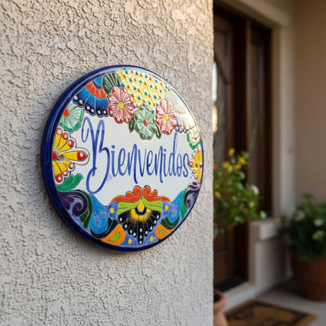 The Talavera Hub hand-painted ceramic Bienvenidos plaque with floral border in blue, orange, green, yellow, and red.