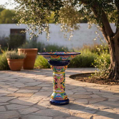 The Talavera Hub large ceramic bird bath with blue rim and colorful hand-painted Mexican folk art patterns. Stands 27" tall.