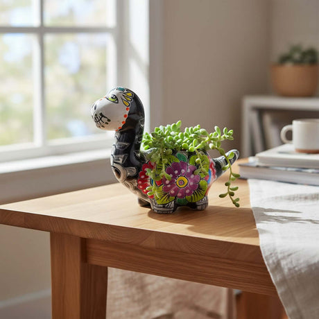 The Talavera Hub black ceramic brachiosaurus planter with hand-painted floral Day of the Dead motifs in vibrant colors.