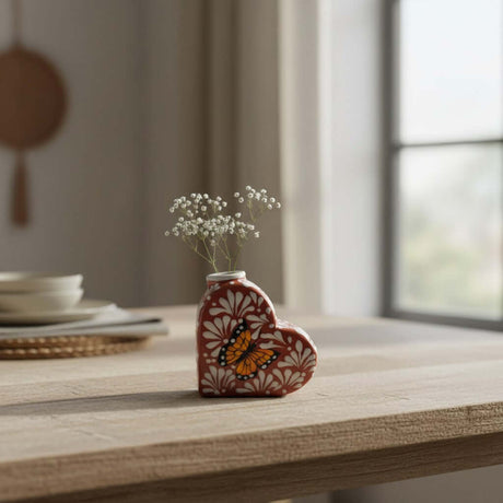 The Talavera Hub brown and white heart-shaped ceramic vase with a hand-painted butterfly design and delicate white flowers.