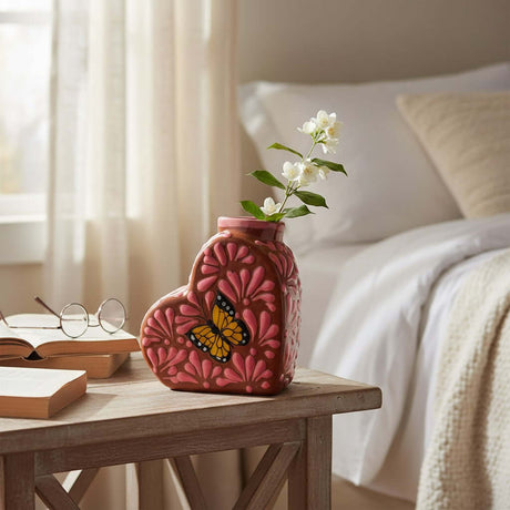 The Talavera Hub pink heart-shaped ceramic vase with a monarch butterfly design and floral accents.