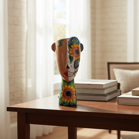 The Talavera Hub ceramic planter features a half-and-half face design with one side natural and the other a Day of the Dead skull motif with sunflowers.