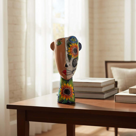 The Talavera Hub ceramic planter features a half-and-half face design with one side natural and the other a Day of the Dead skull motif with sunflowers.