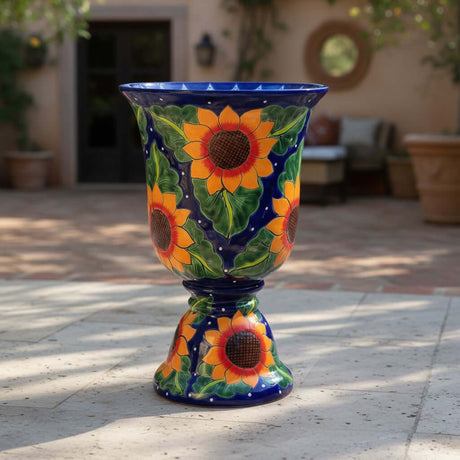 The Talavera Hub Cobalt Blue Sunflower Pedestal Planter, a large ceramic garden pot with hand-painted sunflowers and glossy glaze.