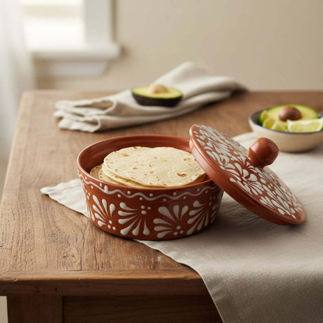The Talavera Hub terracotta tortilla warmer with hand-painted white floral design. Glazed finish, 6" H x 7.5" W.