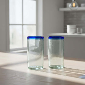 The Talavera Hub hand-blown clear glass tumblers with cobalt blue rims. Set of 2, 18 oz capacity, 6" tall.
