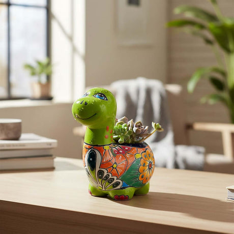 The Talavera Hub handcrafted ceramic Brachiosaurus planter with vibrant floral patterns and a small succulent.