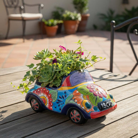 The Talavera Hub handmade ceramic car planter with colorful hand-painted floral folk art patterns and succulents.