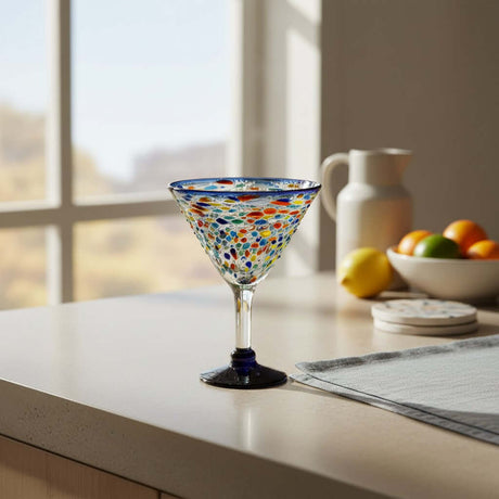The Talavera Hub hand-blown glass martini glass with confetti pattern and blue rim and base. Holds 12 oz.
