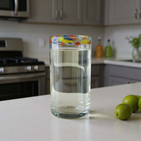 The Talavera Hub hand-blown glass tumbler with a clear body and a colorful confetti rim. Ideal for everyday use or festive occasions.