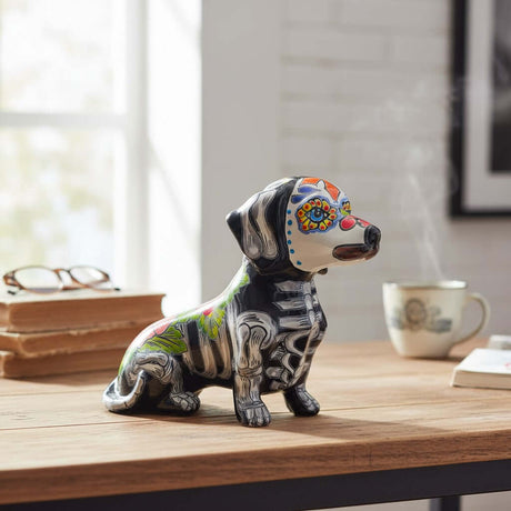 The Talavera Hub black ceramic dachshund figurine with Day of the Dead floral and skeletal motifs, hand-painted glaze.
