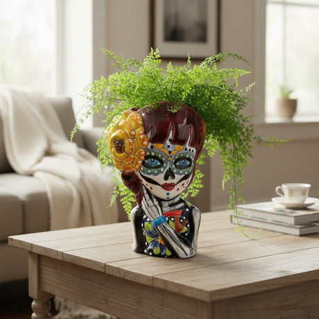 The Talavera Hub handmade ceramic Day of the Dead face planter, hand-painted with floral patterns and a yellow flower.