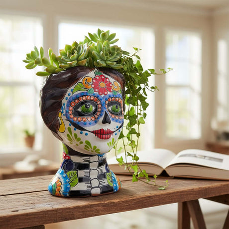 The Talavera Hub hand-painted ceramic Day of the Dead skull planter with green eyes and floral designs.
