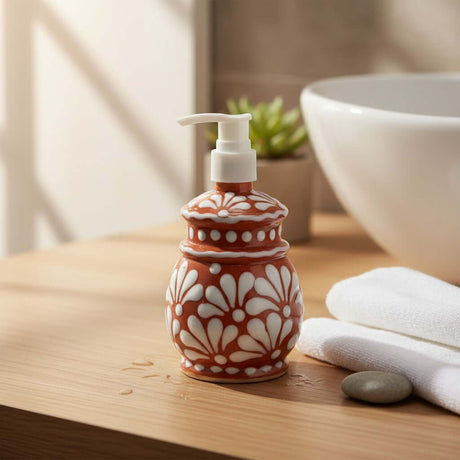The Talavera Hub handcrafted ceramic soap dispenser with brown and white floral patterns on a wooden countertop.