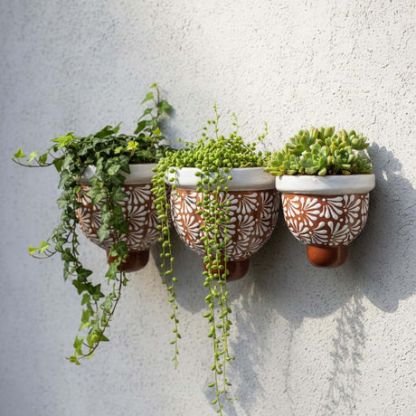 The Talavera Hub set of 3 handcrafted brown and white floral ceramic wall planters with trailing succulents