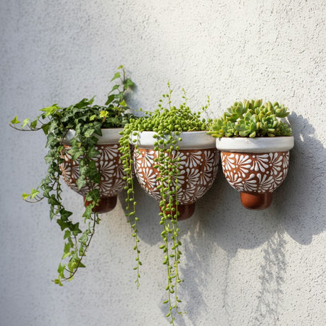 The Talavera Hub set of 3 handcrafted brown and white floral ceramic wall planters with trailing succulents