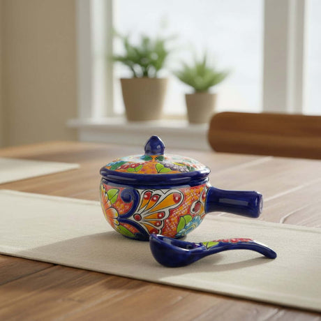 The Talavera Hub hand-painted ceramic soup bowl with lid and matching spoon featuring vibrant Mexican floral patterns.