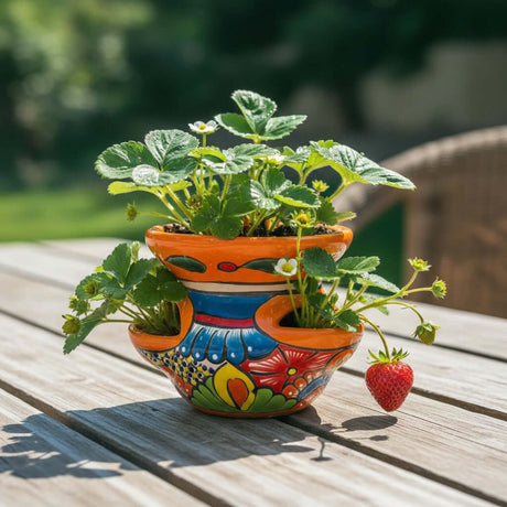 The Talavera Hub hand-painted ceramic strawberry planter with floral patterns in orange, blue, and red. Features side pockets.