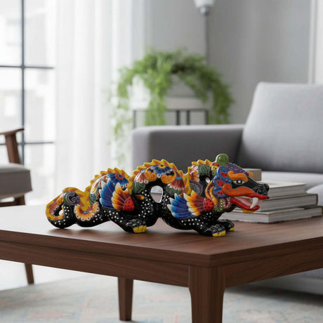 The Talavera Hub handmade black ceramic dragon statue with vibrant multicolored floral and feather details, 23" long.