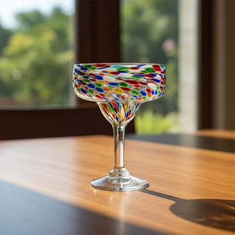 The Talavera Hub hand-blown Mexican margarita glass with colorful pebbled confetti design and clear stem.