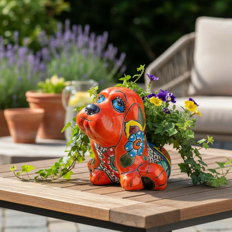 The Talavera Hub medium orange ceramic dog statue with blue, yellow, and green floral Talavera patterns.