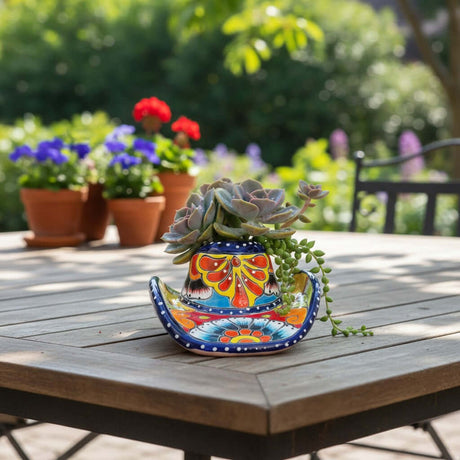 The Talavera Hub hand-painted sombrero planter in vibrant blue, orange, yellow, and red, holding succulents.