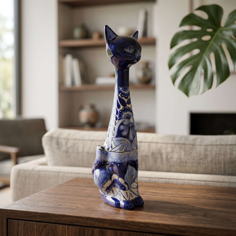 The Talavera Hub handmade tall ceramic cat statue with blue and white floral patterns on a wooden table.