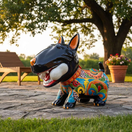 The Talavera Hub extra large ceramic Bull Terrier dog statue, hand-painted with vibrant Talavera patterns and holding a white bone.
