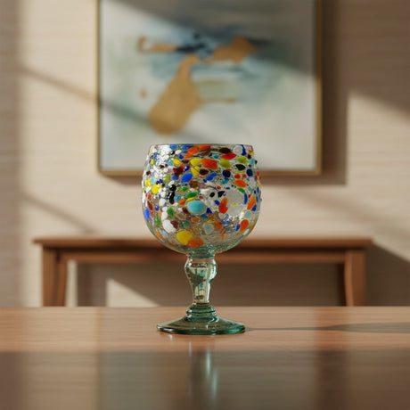 The Talavera Hub oversized fish bowl margarita glass with colorful confetti pebble design. Hand-blown recycled glass, 23 oz.