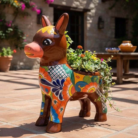 The Talavera Hub hand-painted ceramic donkey planter with floral designs in orange, yellow, green, and blue.