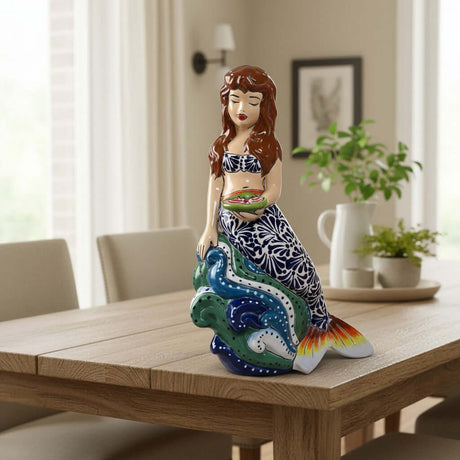 The Talavera Hub hand-painted ceramic mermaid figurine with floral tail, holding a fish. Coastal decor.