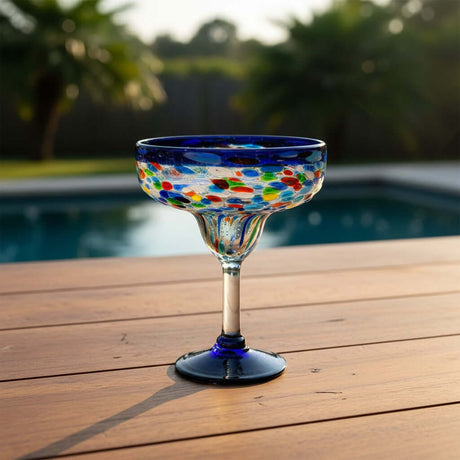 The Talavera Hub Mexican hand-blown margarita glasses with blue confetti rock design and dark blue bases.