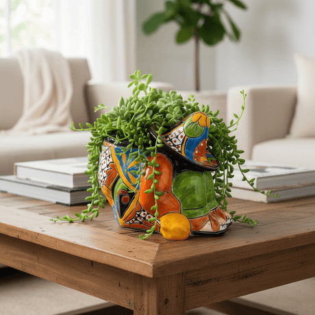 The Talavera Hub colorful ceramic planter shaped like a sleeping man in a sombrero, hand-painted with orange, blue, green, and red.