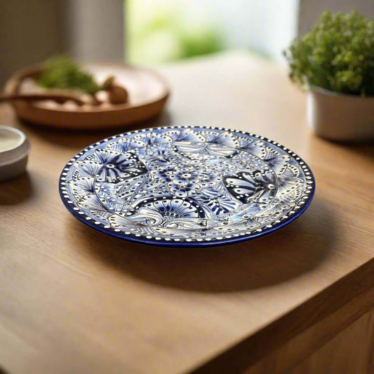 Blue-and-white floral Talavera dinner plate resting on a wooden dining table