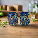 Confetti Rimmed Shot Glass | Hand-Blown Mexican Glassware with Blue Rim - pair of hand-blown multicolor confetti shot glasses with deep blue rim on wooden surface