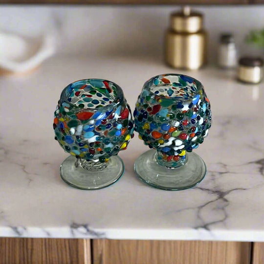 Confetti Rock Shot Glass | Handcrafted Mexican Cognac-Style Glass - pair of hand-blown confetti glass cognac-style shot glasses on marble counter