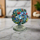 Confetti Rock Shot Glass | Handcrafted Mexican Cognac-Style Glass - hand-blown lead-free confetti rock shot glass on marble countertop, vibrant multicolor beads