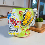 Colorful Talavera Skull Mug | Handcrafted Ceramic Coffee Cup - hand-painted skull mug with yellow butterfly and floral motifs on green background