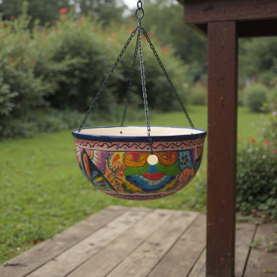 The Talavera Hub hand-painted ceramic hanging planter with blue rim, floral and geometric motifs. Includes chain and drainage hole.