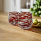 Red Swirl Stemless Wine Glass | Hand-Blown Mexican Glassware - pair of hand-blown red and white swirl stemless wine glasses on wooden table